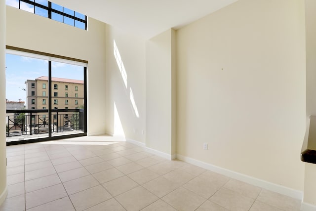 tiled spare room featuring baseboards