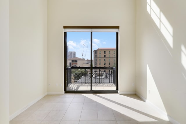 empty room with baseboards and tile patterned floors