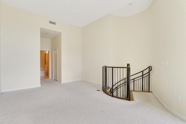 carpeted empty room with visible vents and baseboards