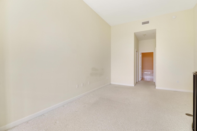 spare room featuring light carpet, visible vents, and baseboards