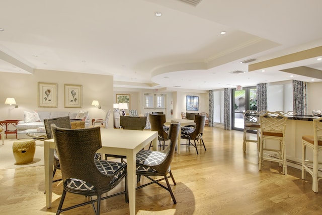 dining space with crown molding, recessed lighting, a raised ceiling, visible vents, and light wood-style flooring