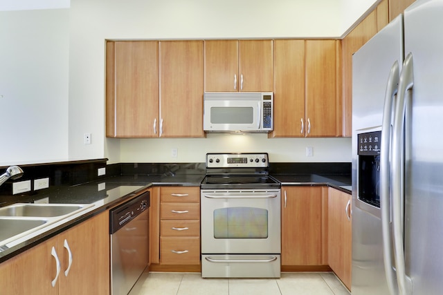 kitchen featuring stainless steel appliances, a sink, and light tile patterned floors