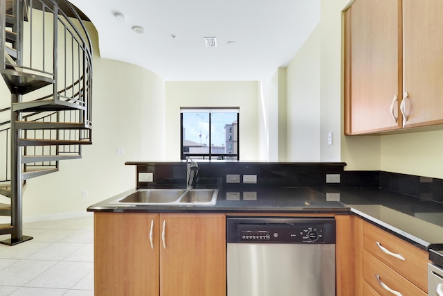 kitchen featuring light tile patterned floors, a peninsula, a sink, dishwasher, and dark countertops