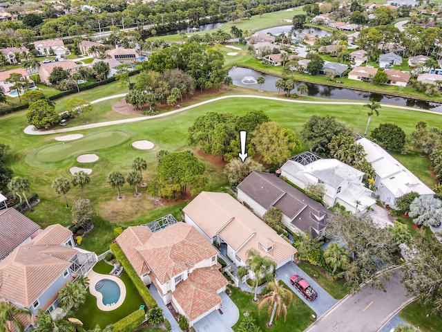 drone / aerial view with view of golf course, a water view, and a residential view