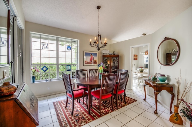 dining room featuring light tile patterned floors, a textured ceiling, and a chandelier