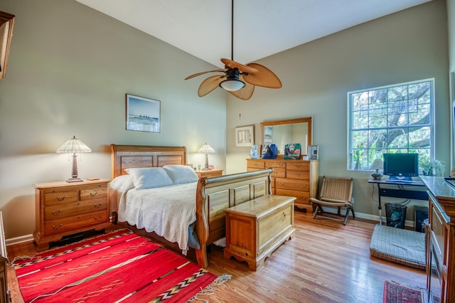 bedroom featuring lofted ceiling, light wood-style flooring, and baseboards