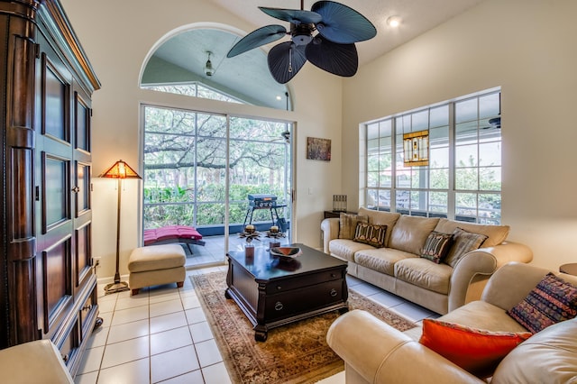 living area with light tile patterned floors, ceiling fan, and high vaulted ceiling