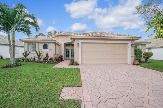 view of front of property featuring a garage, stucco siding, a tile roof, decorative driveway, and a front yard