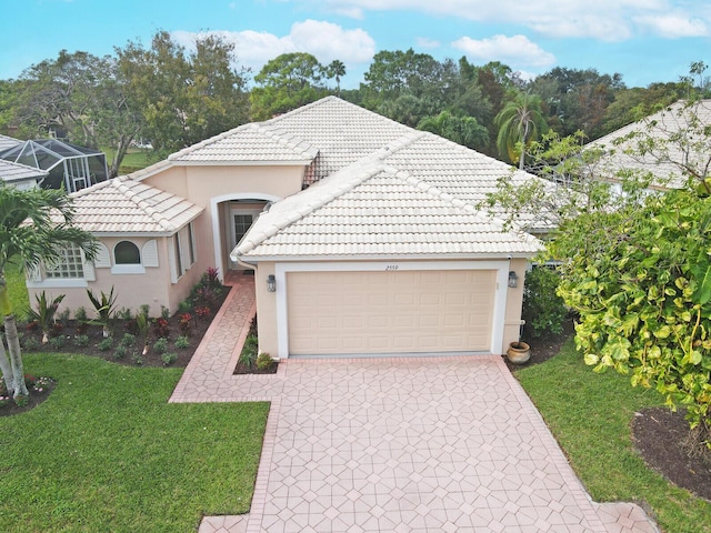 view of front of property with a garage, a tiled roof, decorative driveway, stucco siding, and a front lawn