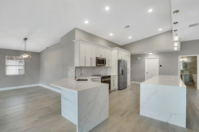 kitchen with tasteful backsplash, visible vents, vaulted ceiling, stainless steel appliances, and a sink