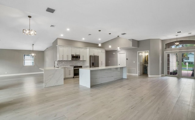 kitchen with appliances with stainless steel finishes, visible vents, a notable chandelier, and backsplash