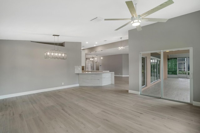 unfurnished living room with visible vents, baseboards, light wood-style flooring, ceiling fan with notable chandelier, and recessed lighting