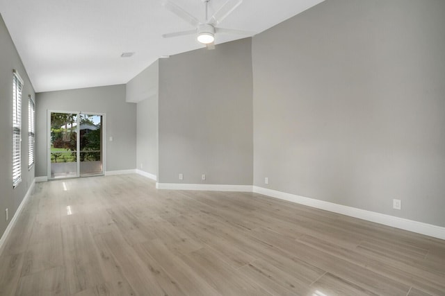 empty room featuring a ceiling fan, light wood-type flooring, vaulted ceiling, and baseboards