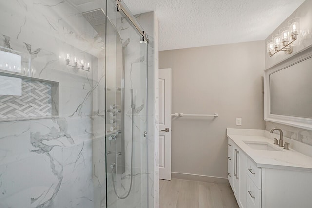 full bath with a textured ceiling, wood finished floors, a marble finish shower, and vanity