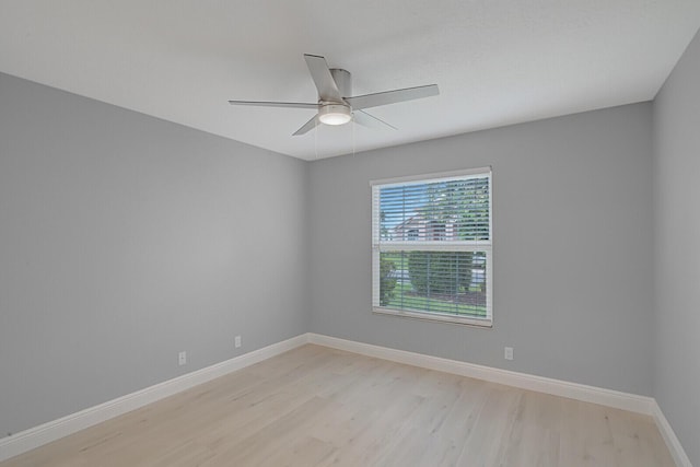 empty room with ceiling fan, light wood-style flooring, and baseboards