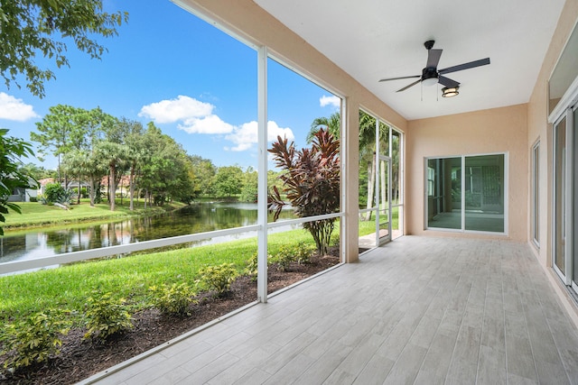 unfurnished sunroom featuring a water view and ceiling fan