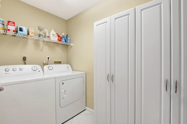 washroom featuring light tile patterned floors, laundry area, baseboards, and washer and dryer