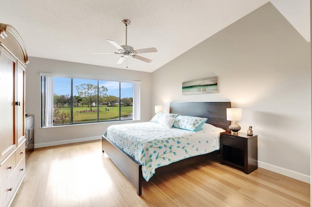 bedroom with lofted ceiling, baseboards, a ceiling fan, and light wood-style floors