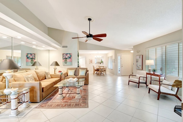 living area with lofted ceiling, light tile patterned floors, visible vents, and ceiling fan with notable chandelier