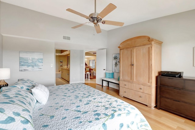 bedroom featuring ceiling fan, light wood finished floors, and a high ceiling