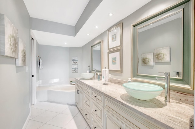 bathroom featuring a bath, double vanity, a sink, and tile patterned floors