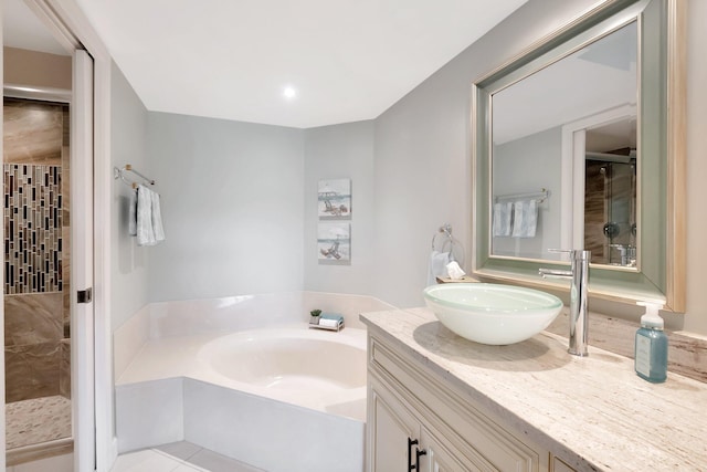 full bathroom featuring a garden tub, a shower stall, tile patterned flooring, and vanity