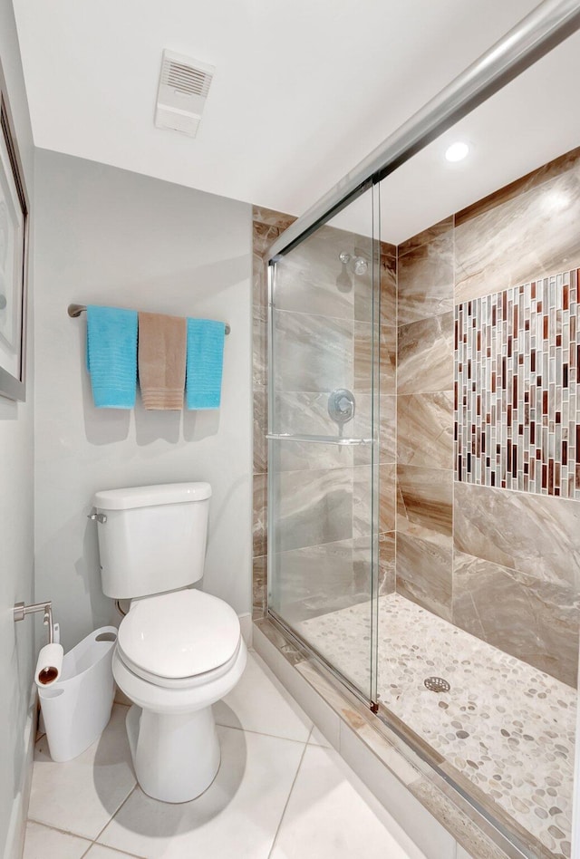 full bathroom with a stall shower, tile patterned flooring, visible vents, and toilet