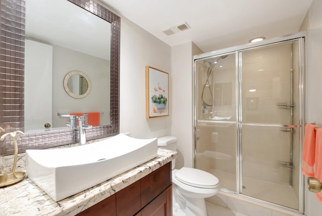 full bathroom with toilet, vanity, a shower stall, and visible vents