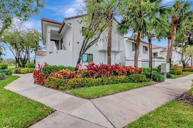 exterior space featuring a front lawn and stucco siding