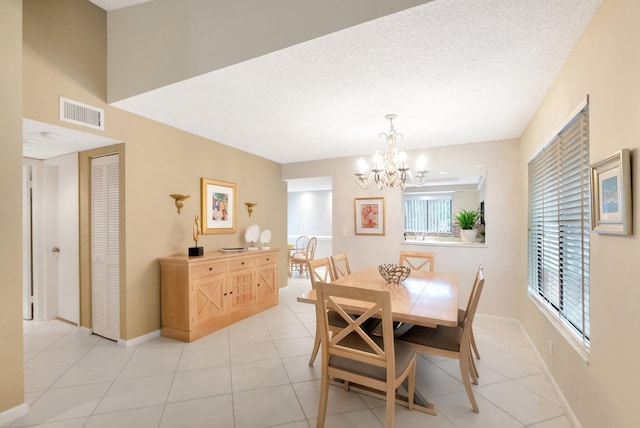 dining room featuring light tile patterned floors, visible vents, an inviting chandelier, a textured ceiling, and baseboards