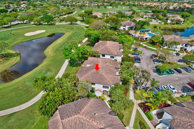 drone / aerial view with view of golf course, a water view, and a residential view