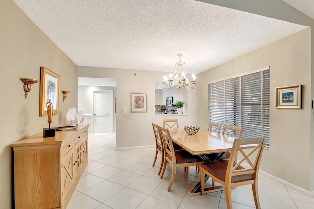 dining space featuring baseboards, a textured ceiling, an inviting chandelier, and light tile patterned floors