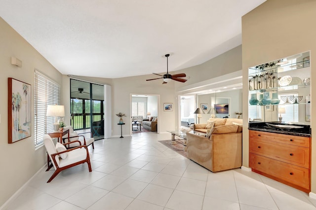 living room with light tile patterned floors, ceiling fan, and baseboards