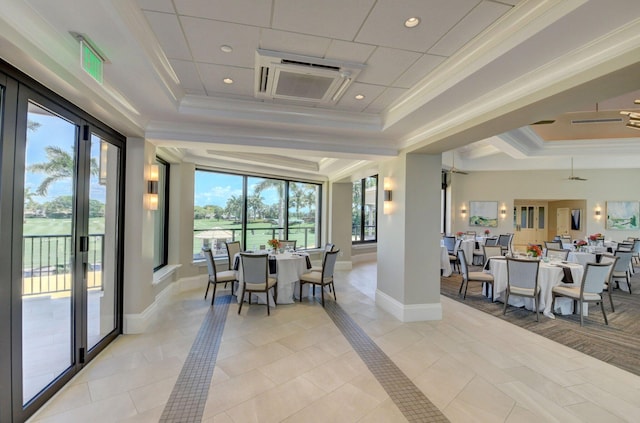 dining space with a tray ceiling and ornamental molding