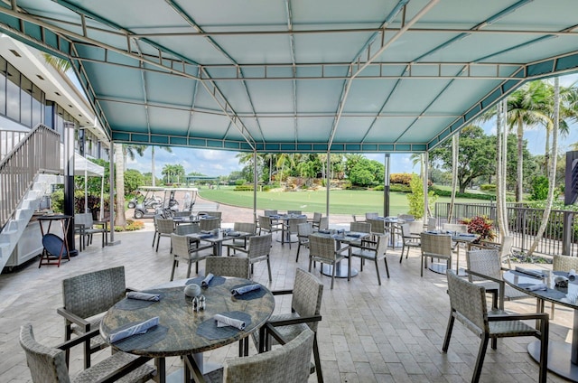 view of patio / terrace with stairs, fence, and outdoor dining space