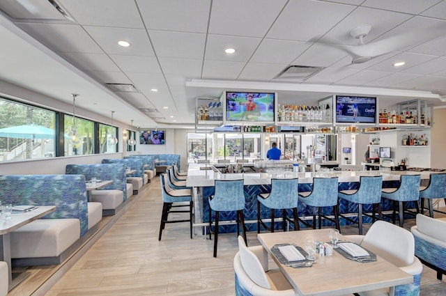 bar featuring light wood finished floors, wet bar, a wealth of natural light, and recessed lighting