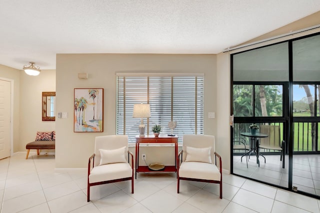 sitting room featuring light tile patterned floors, plenty of natural light, and a textured ceiling