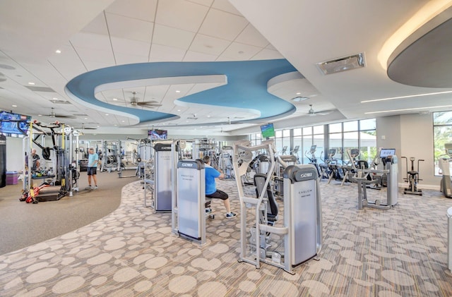 workout area with ceiling fan, carpet floors, a raised ceiling, and recessed lighting