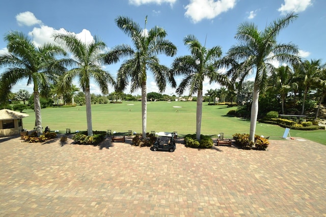 view of home's community with view of golf course and a lawn