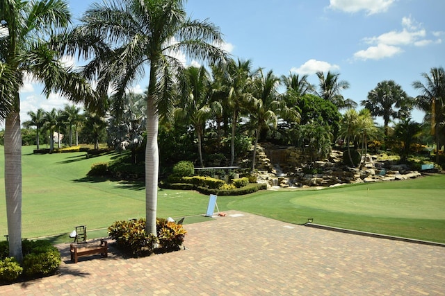 surrounding community featuring view of golf course and a lawn