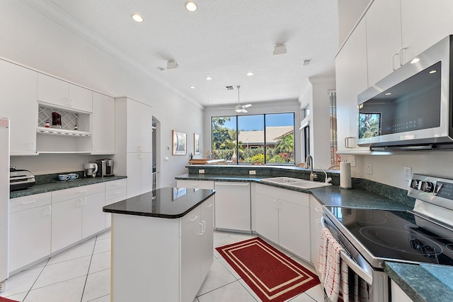 kitchen featuring light tile patterned floors, appliances with stainless steel finishes, open shelves, and a sink