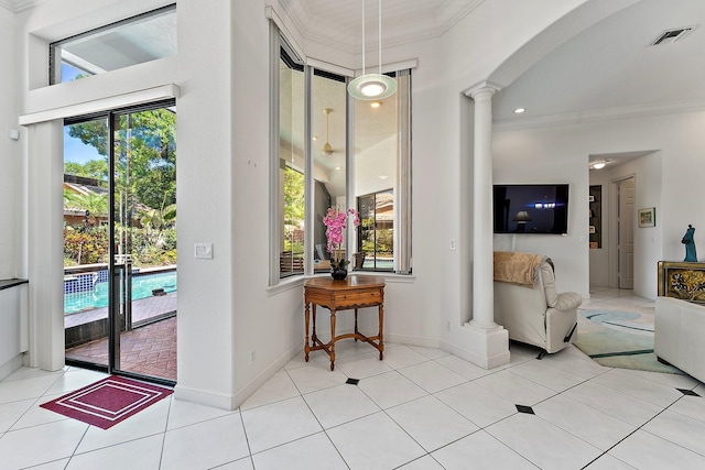 interior space with visible vents, arched walkways, baseboards, crown molding, and ornate columns