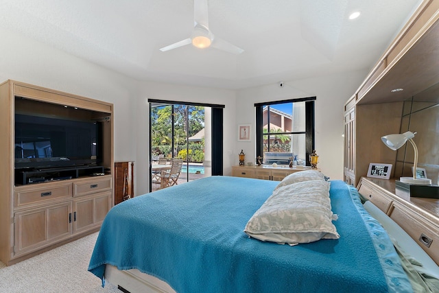 bedroom featuring carpet, a raised ceiling, a ceiling fan, and access to exterior