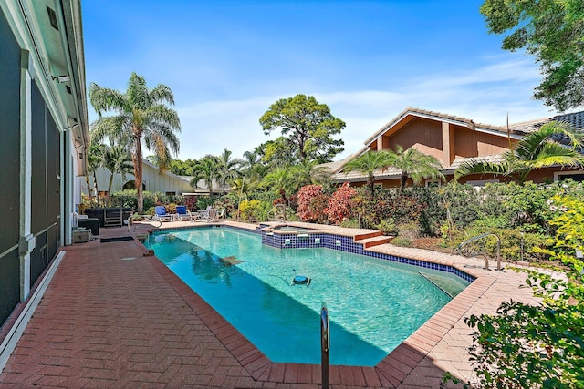 view of pool with a patio area and a pool with connected hot tub