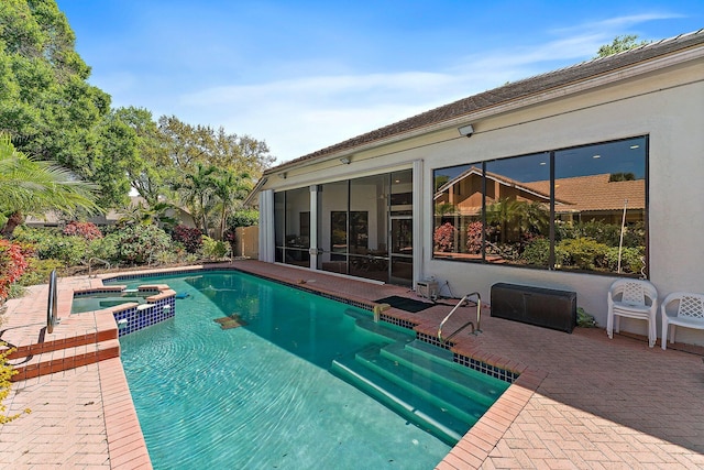 view of swimming pool featuring a sunroom, a pool with connected hot tub, and a patio