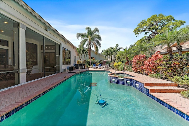 view of swimming pool featuring a pool with connected hot tub and a patio