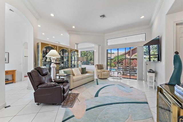 living area featuring arched walkways, recessed lighting, visible vents, ornamental molding, and light tile patterned flooring