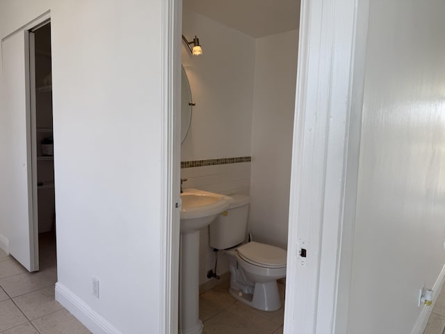 half bath featuring toilet and tile patterned floors