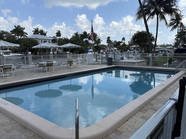 pool with a patio and fence