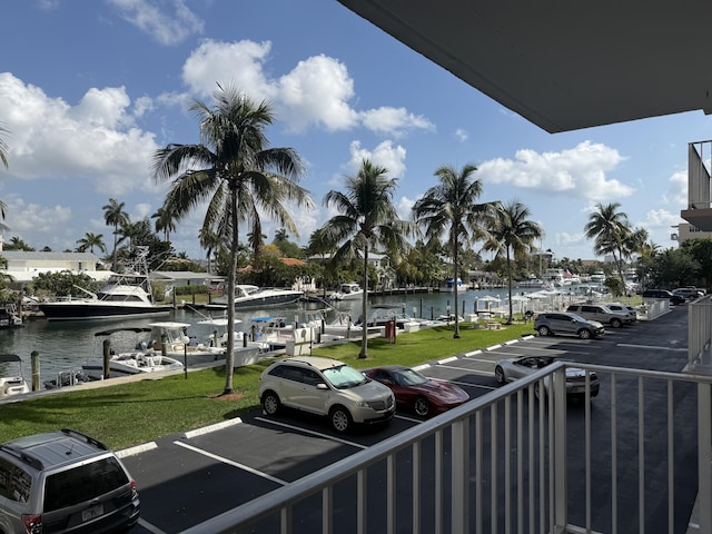 uncovered parking lot featuring a water view and a dock